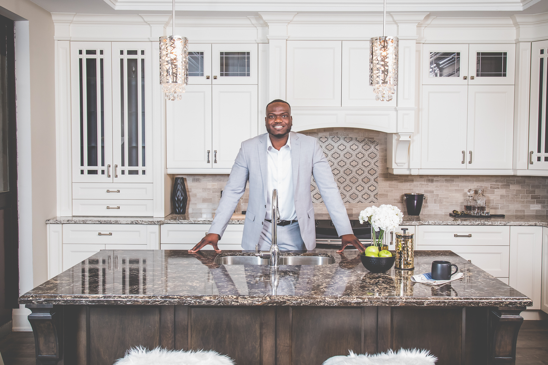 Durham Region Realtor Kenneth Toppin standing at the island of a bright modern kitchen